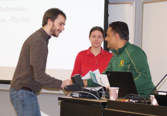 Jarryd Horn (left) and Mariah Goeks receive the Technology Innovation Award from Professor Yuba Gautam.