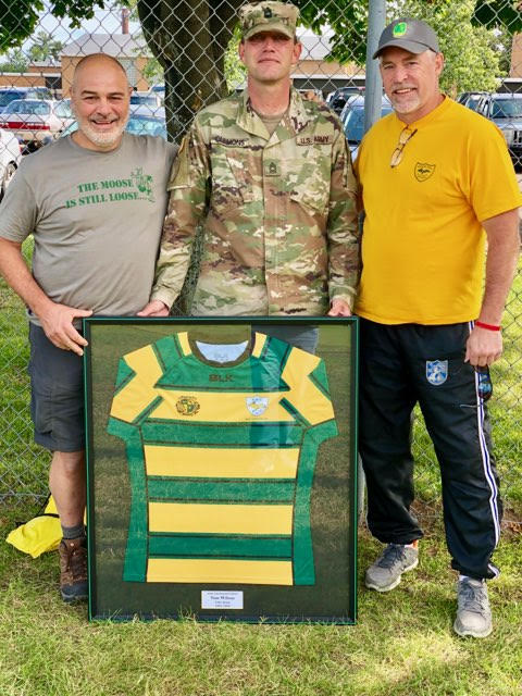 Original coach Chuck Delpier, MSG Donald Clemons and alumnus Steve Nemeckay with the jersey for Wilson.