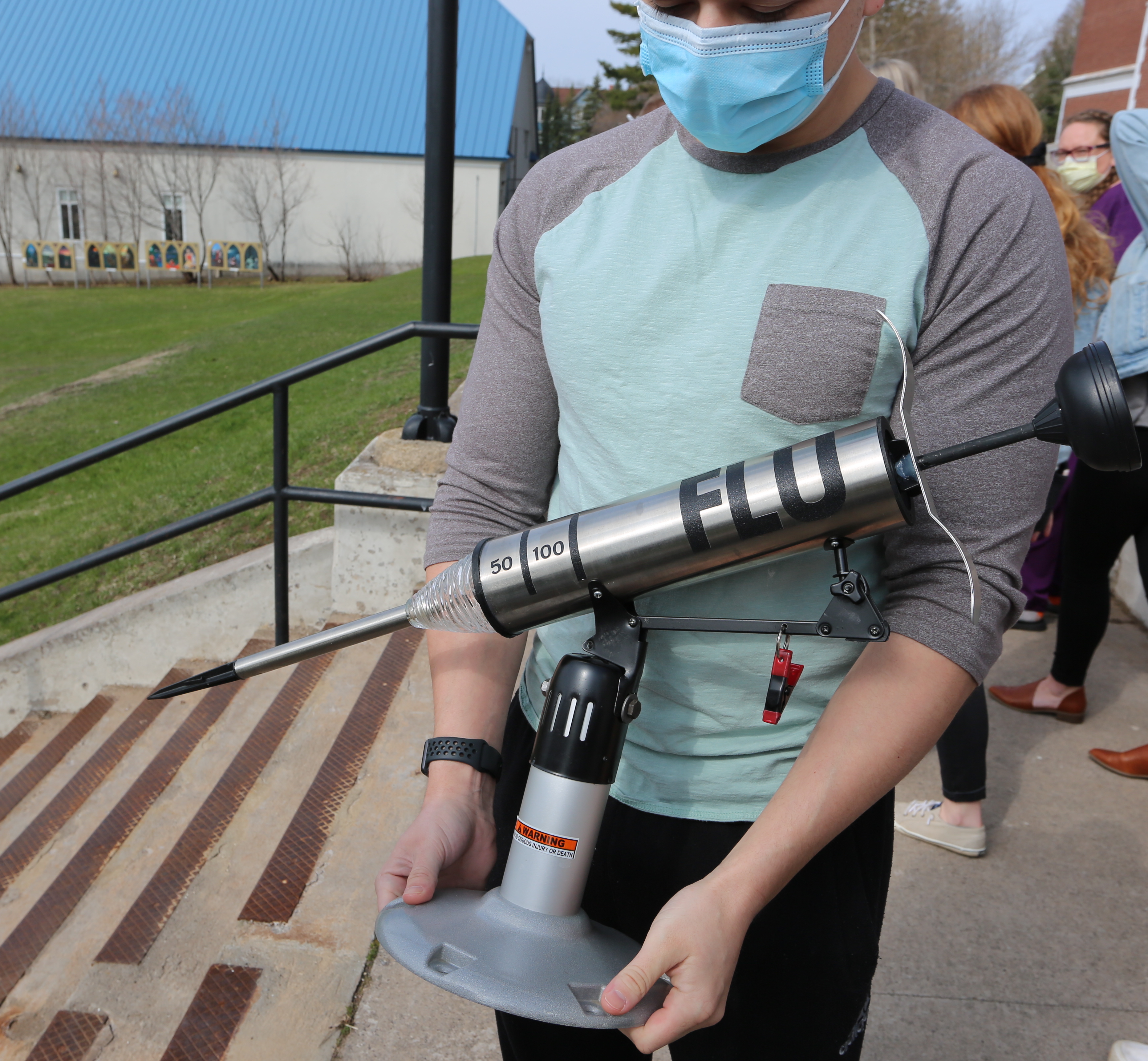 A Finlandia student with the traveling winners trophy crafted by NMU Art & Design Professor Dale Wedig