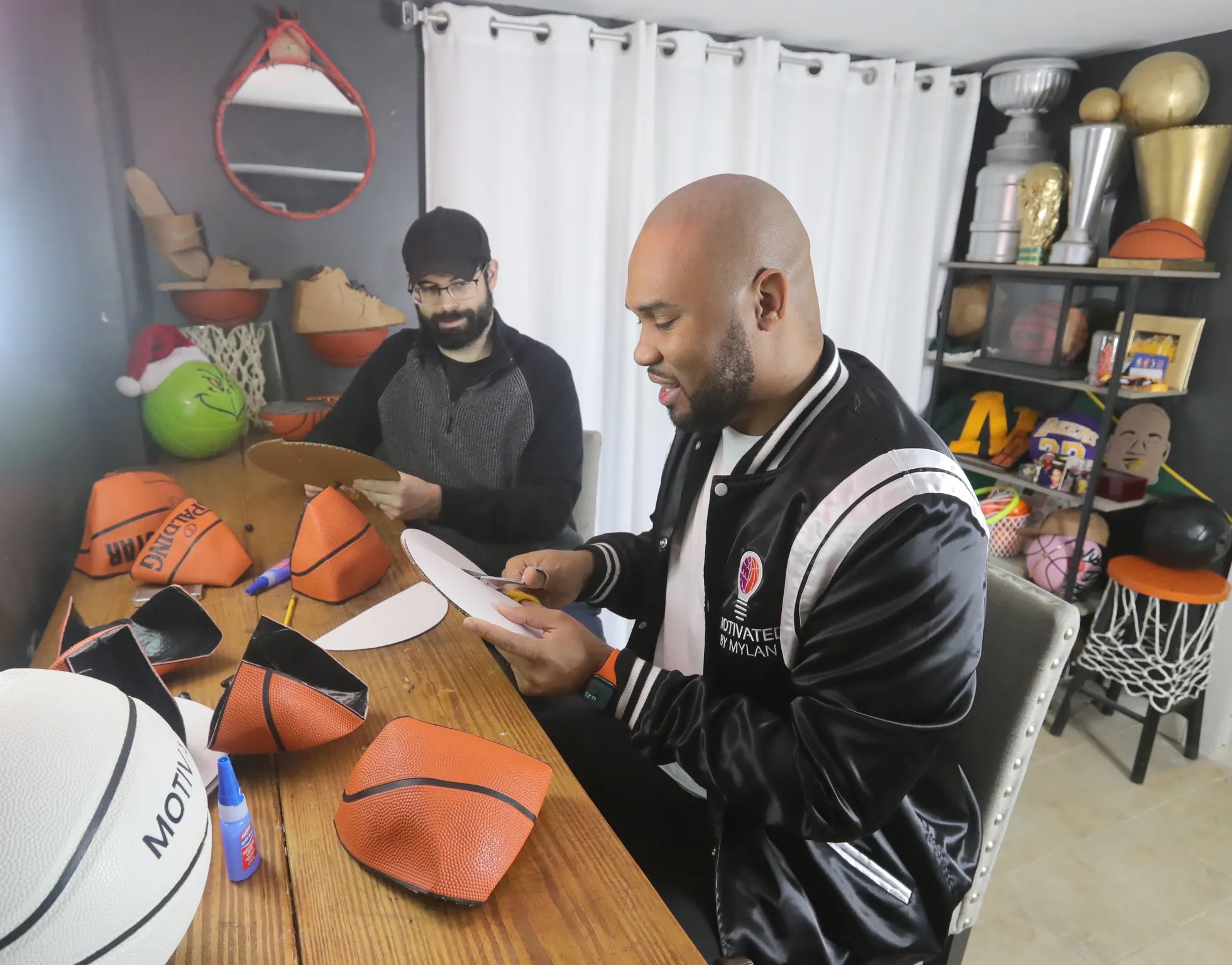 Murphy helping an Akron Beacon Journal reporter create a floating basketball shelf (Phil Masturzo photo).