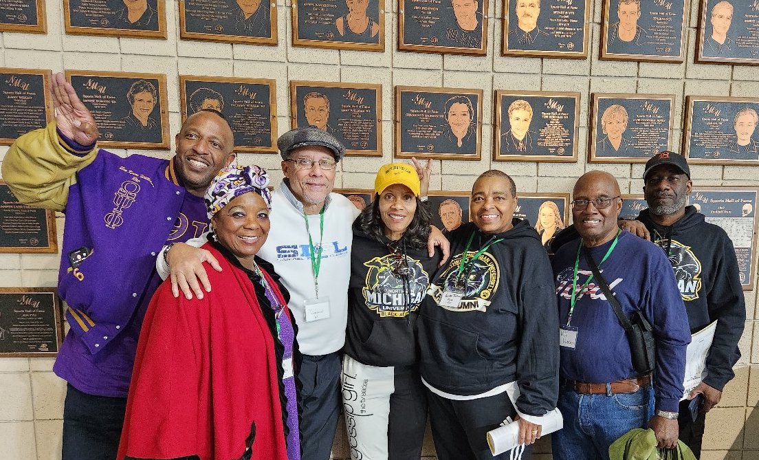 NMU Hall of Fame inductee Gwen Jackson (third from right) with others in front of her plaque in the Superior Dome. She played basketball for NMU in the early '80s and was inducted in the hall in 2006.