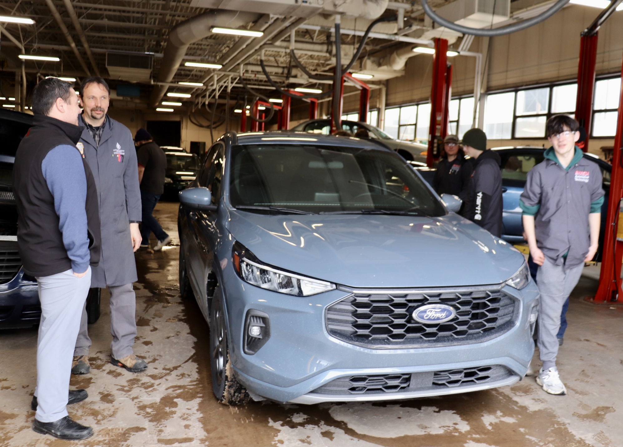 Fox Marquette's Luke Hubbard and NMU professor Randal Klitzke chat while a student checks out the vehicle.