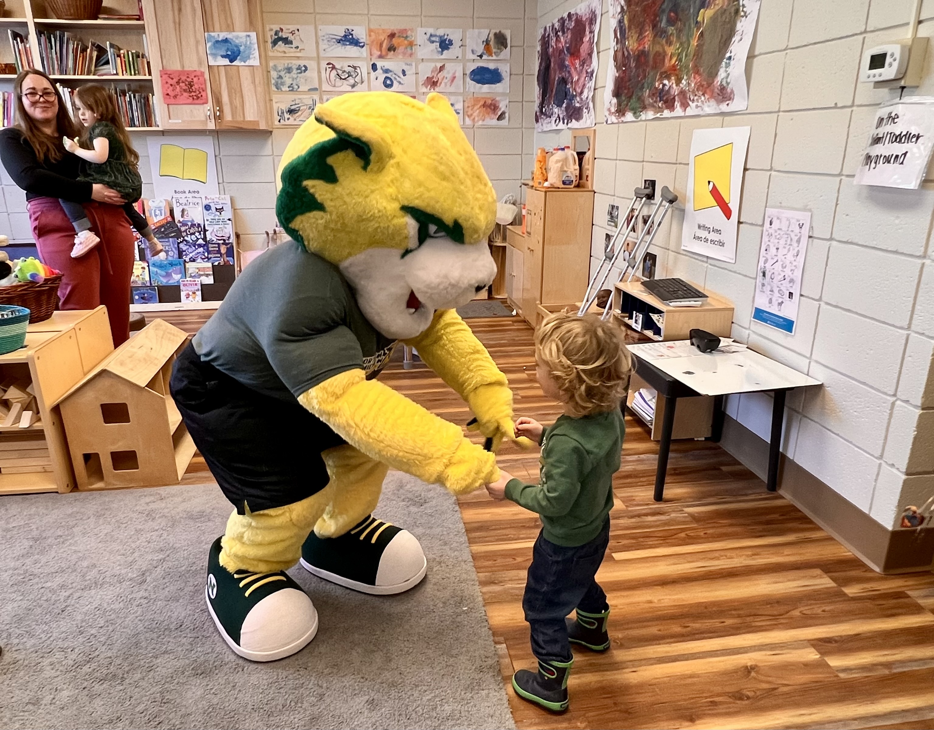 Wildcat Willy interacts with a child in a classroom.