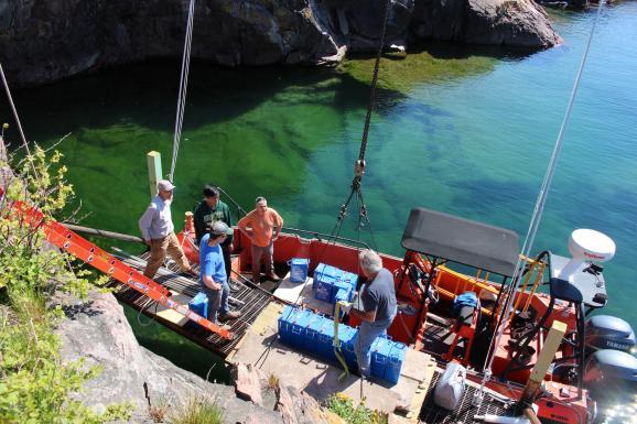 Image of members unloading batteries from a boat