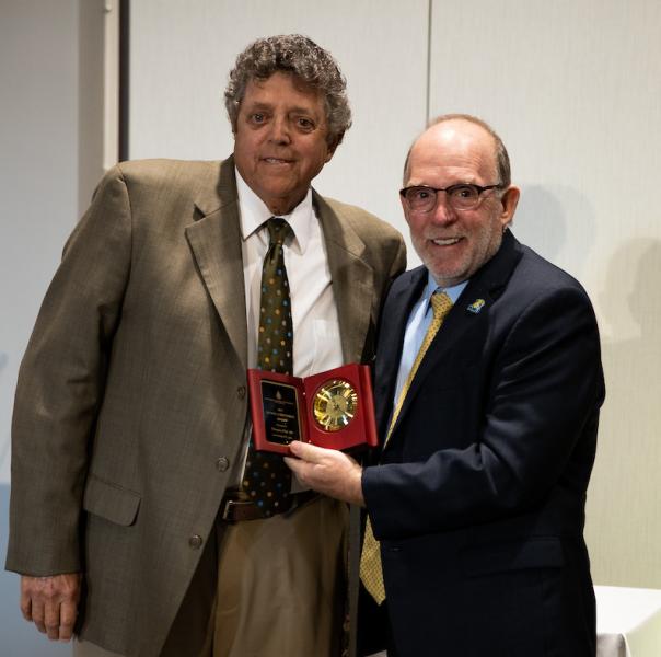 Tom Fish (left) accepting his award from NMU President Fritz Erickson