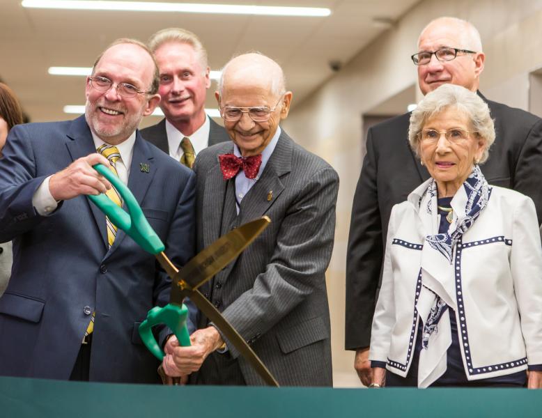 June Jamrich (far right) watches as NMU President Fritz Erickson and former President John X. Jamrich cut the ribbon for the new Jamrich Hall dedication in 2014.