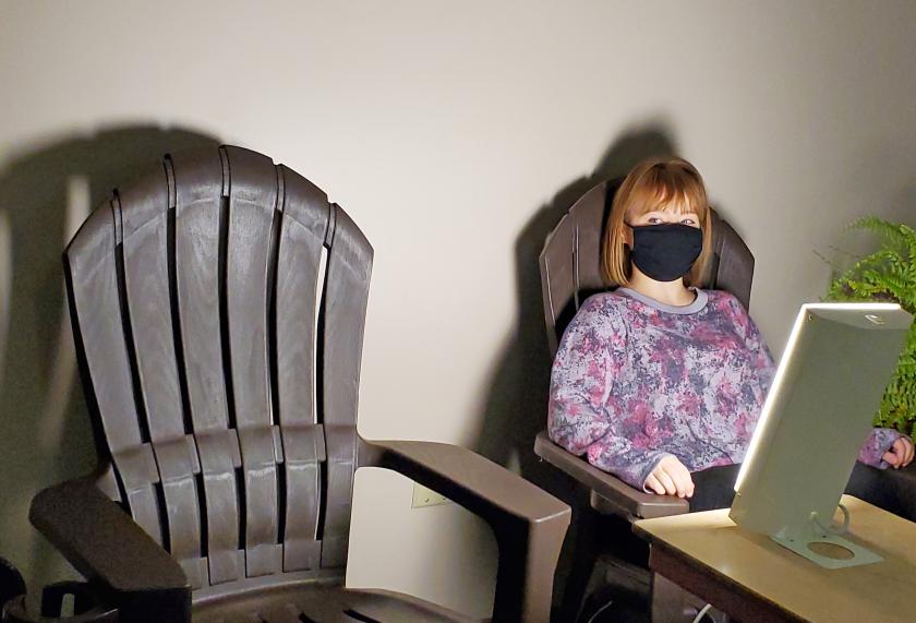 NMU student employee Raija Stille tries out one of the chairs near the sun lamp.