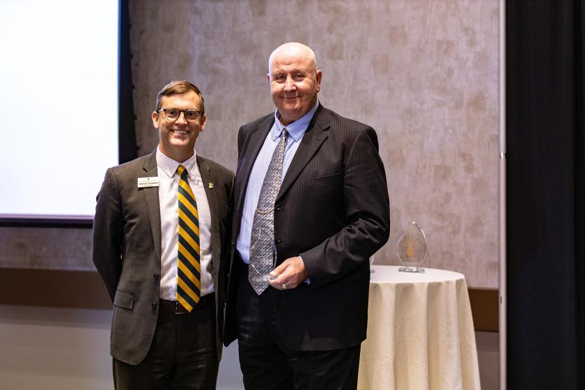 Charles Hawes accepts the Alumni Service Award from NMU President Brock Tessman