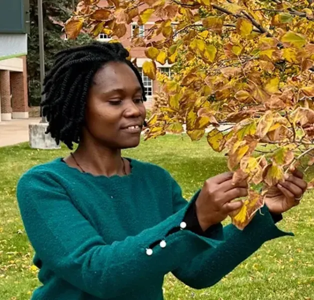 Ugandan visiting scholar Justine Nakintu on campus last semester exploring the fall leaves.