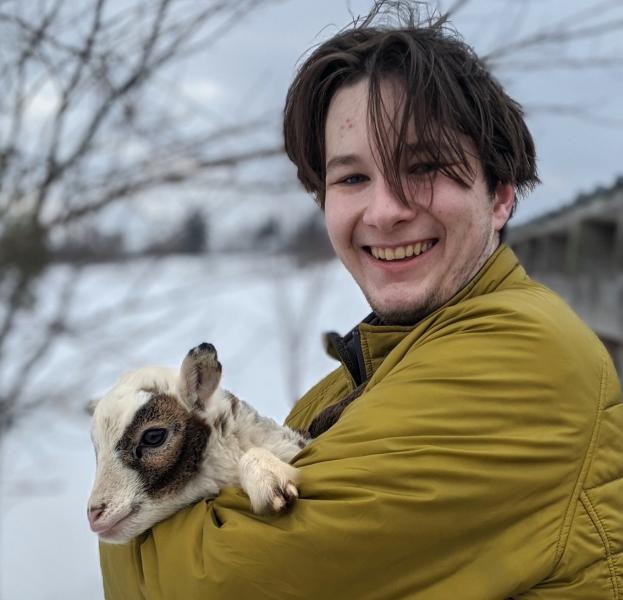 Tucker McLain holding a baby goat named Little Snickers.