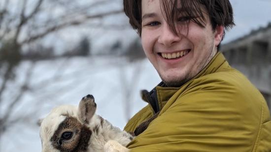 Tucker McLain holding a baby goat named Little Snickers.