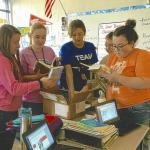 Students in Townsend's classroom review the books donated by NMU.