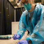 NMU stock photo of campus mass testing event and the PPE nursing students wear regularly.