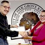 Cook (left) receives the award from Oak Grove Mayor Theresa Jarvis.