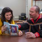 File photo of Reinhardt (right) showing a student a book on Great Lakes Native Americans.