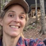 Mittlefehldt in front of her wood pile at camp.