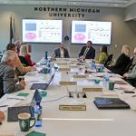 Alex Wilson and Matthew Jennings (back center) give a presentation to the NMU Board of Trustees