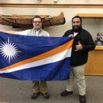 Alik (right) presents the flag to NMU's Joe Lubig.