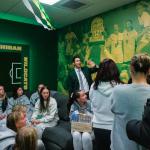 Sandoval (center) points to the updated mural featuring photos from last year's GLIAC Championship during an open house for the renovated locker room earlier this season.